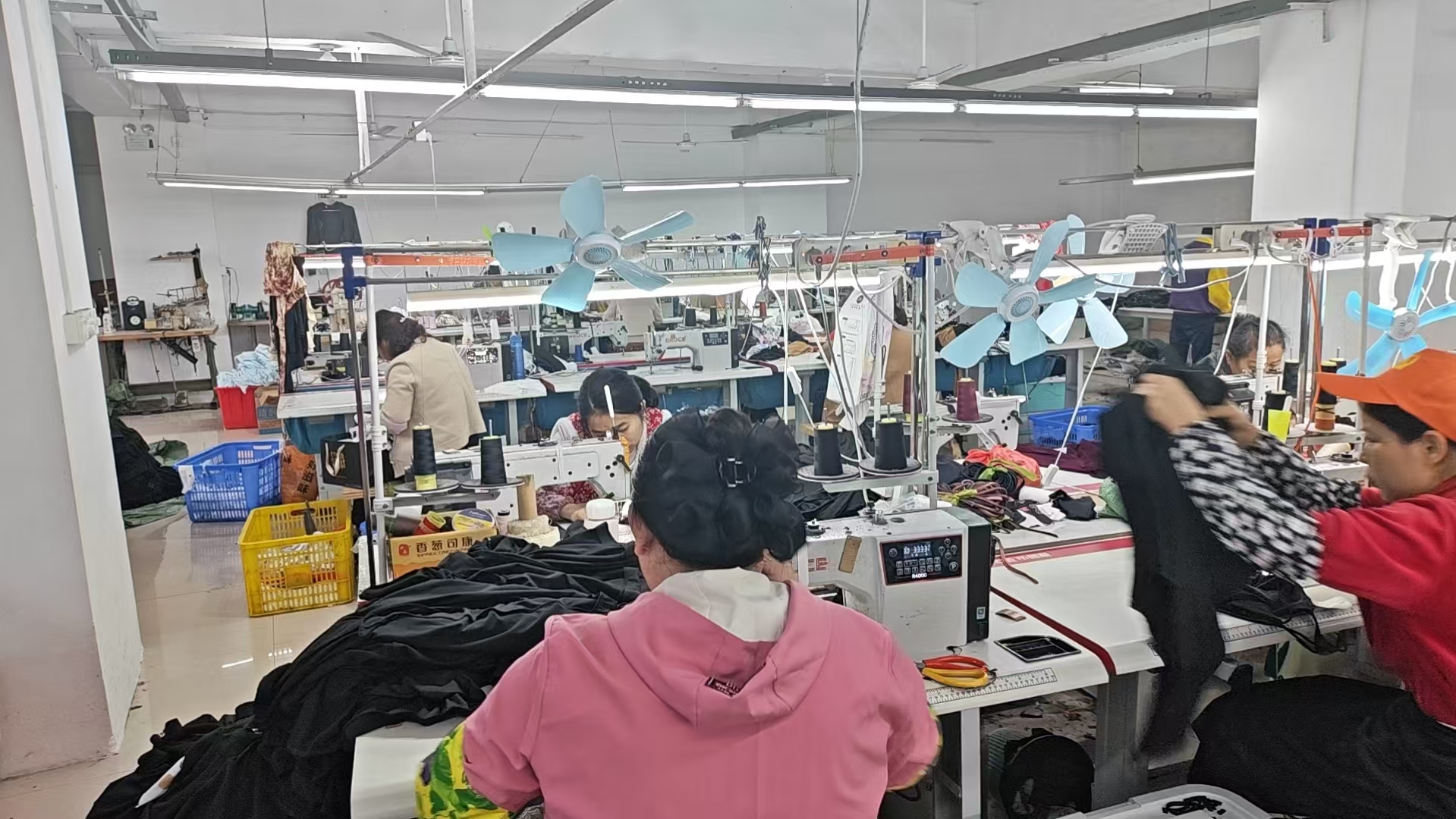 Garment workers at sewing machines in the YATAI CLOTHING workshop.